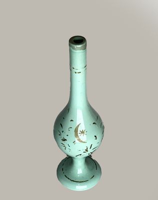 a green vase that has a crescent on it