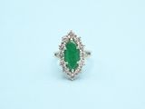 a close up of a ring with a green stone in it