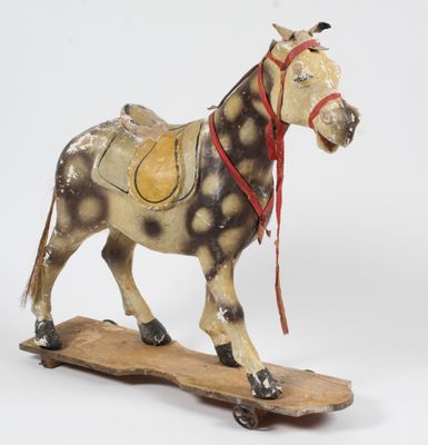 statue d'un cheval sellé posée sur une planche en bois