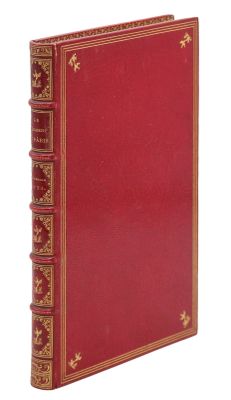 un vieux livre avec une couverture rouge et des bordures dorées sur fond blanc
