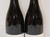 deux bouteilles de vin posées sur une table l'une à côté de l'autre