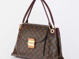a louis vuitton handbag with gold hardware on the handle
