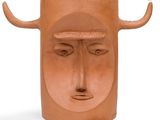 a clay vase with a face and horns on it