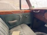 an old car with a broken steering wheel in the back of it