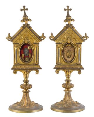 une paire de supports d'horloge en laiton ancien, ornés chacun d'une image représentant un homme et une femme