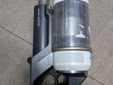 a gun that is sitting on the ground next to a bottle