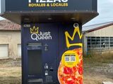 un distributeur automatique sur lequel est posée une pizza