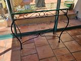 une table en verre sur laquelle se trouve un vase de fleurs
