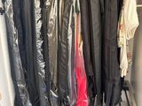 a lot of clothes hanging on a rack in a closet