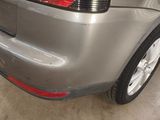 the rear end of a silver car with a red tail light