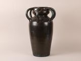 a black vase that is sitting on a white surface