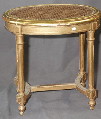 une table dorée avec un plateau en osier sur fond gris
