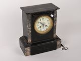 une image représentant une horloge noire et dorée sur fond blanc