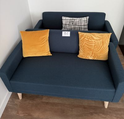un canapé bleu sur lequel sont posés deux coussins jaunes