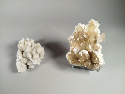 two pieces of white and brown crystals sitting on top of a table