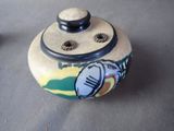 a close up of a small jar with a picture on it