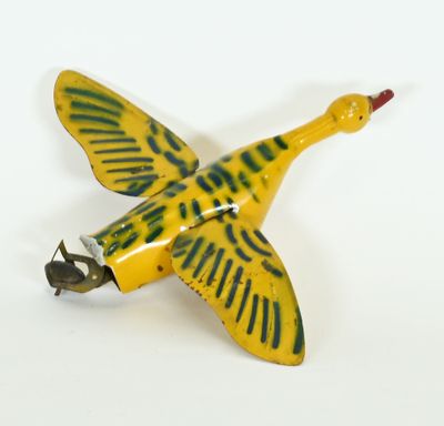 a yellow and green bird shaped object on a white surface