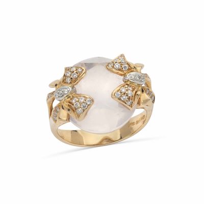 un gros plan d'une bague sertie d'une pierre blanche et de diamants