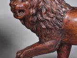 pair of carved wooden lions with ball on grey background