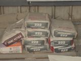 de nombreux cartons de ciment posés sur une étagère dans une pièce