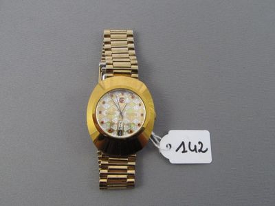 une montre-bracelet en or à laquelle est attachée une étiquette