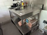 une cuisine équipée d'un plan de travail en inox et où il y a beaucoup de nourriture sur le comptoir