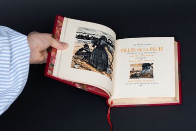 une personne tenant un livre ouvert sur lequel figure une image