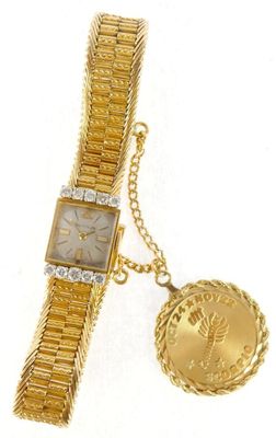 a close up of a wrist watch with a coin attached to it