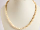 a close up of a necklace on a mannequin with a white background