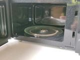 a black microwave with a green plate inside of it