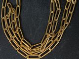 un gros plan d'un collier à chaîne en or sur fond noir