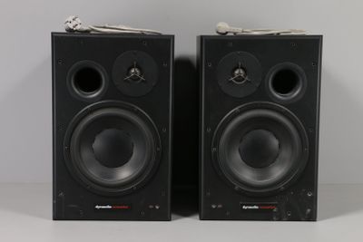 two black speakers sitting side by side on a white surface