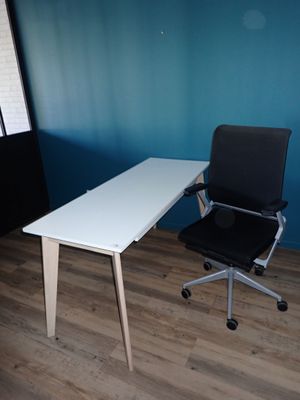 a white desk with a black chair in front of it