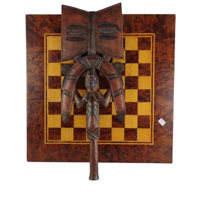 un gros plan d'une sculpture en bois posée sur un échiquier