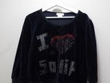 a black shirt with a red heart on it hanging on a hanger