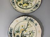 two plates with designs on them are hanging on a wall