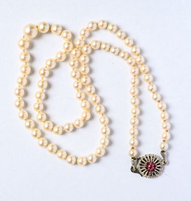 collier de perles orné d'un pendentif en forme de fleur rouge et blanche sur fond blanc