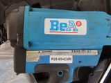 a blue electric drill that is sitting on the ground