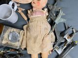 a doll that is laying on a table with other items