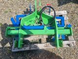 une photo d'une charrue de tracteur verte posée sur une palette en bois