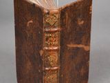 un vieux livre est ouvert sur une table, sur fond gris