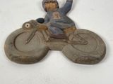 a figurine of a man riding a motorcycle on a white surface
