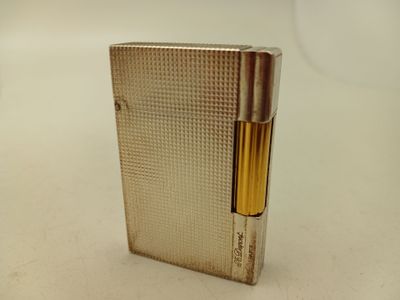 une photo d'un briquet argenté posé sur une table blanche