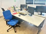 un bureau d'ordinateur avec deux écrans et une chaise bleue devant
