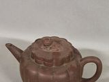 an old brown teapot sitting on top of a white table