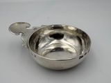 un bol en argent avec une cuillère sur une table