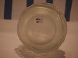a glass vase with a label on it sitting on a table