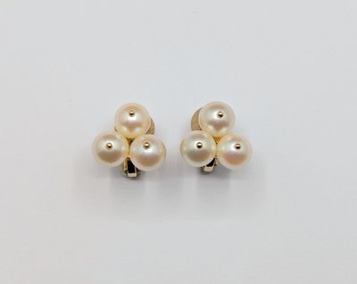 a pair of pearl earrings on a white surface