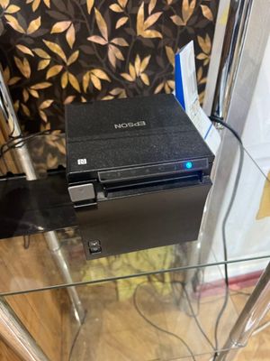 une table en verre sur laquelle se trouve une petite boîte noire