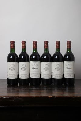 six bouteilles de vin sont alignées sur une table en bois